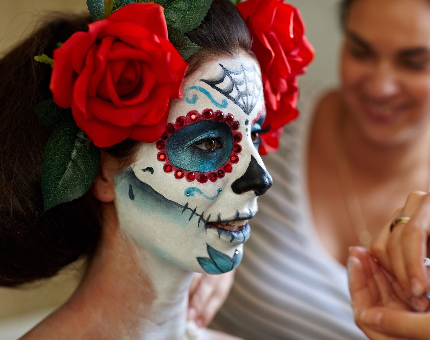 Makeup artists in work making a Halloween makeup - mexican Santa Muerte mask.